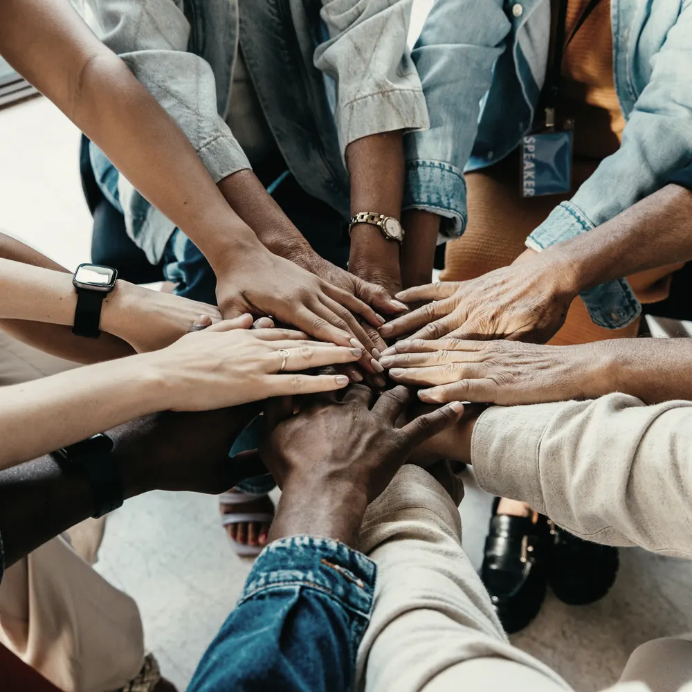 A team stacking their hands together