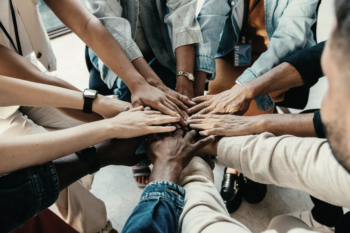 A team stacking their hands together