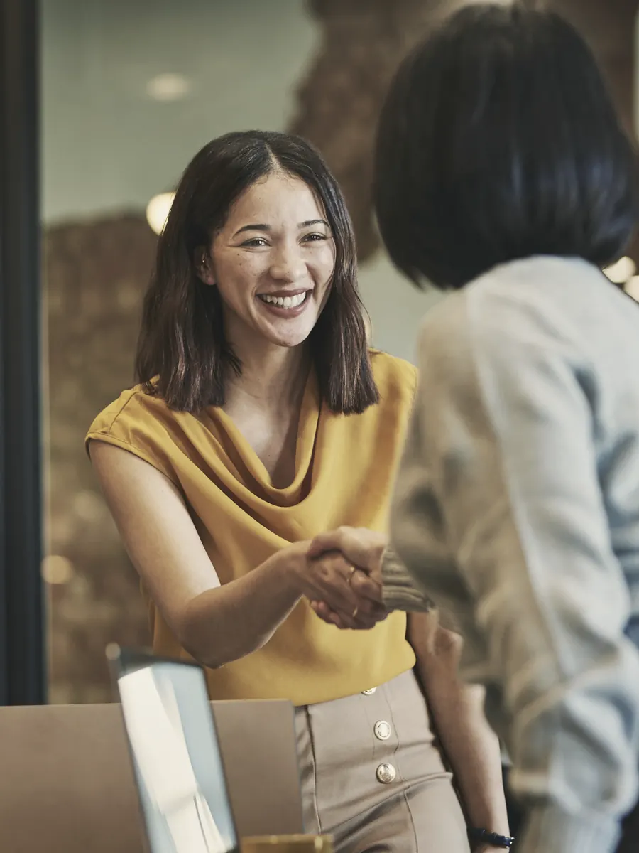 Two colleagues shaking hands at the start of a meeting